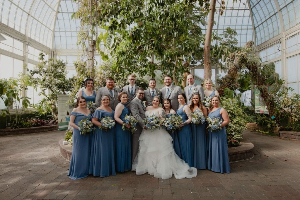 bride's maids and groom's men pose in botanical gardens