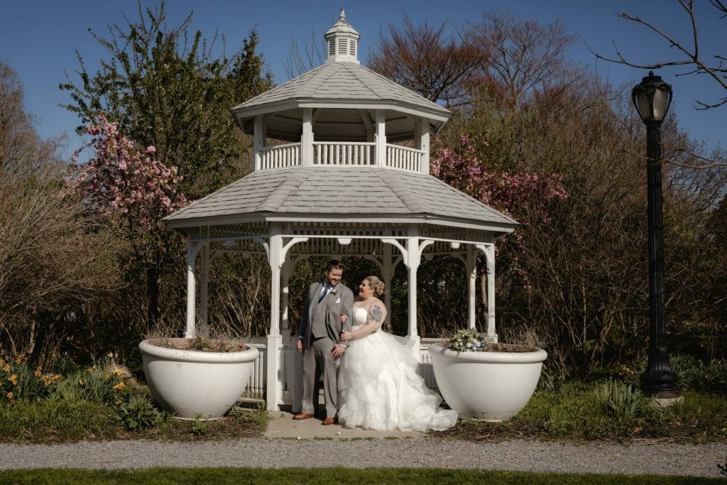 bride and groom stand in gazebo