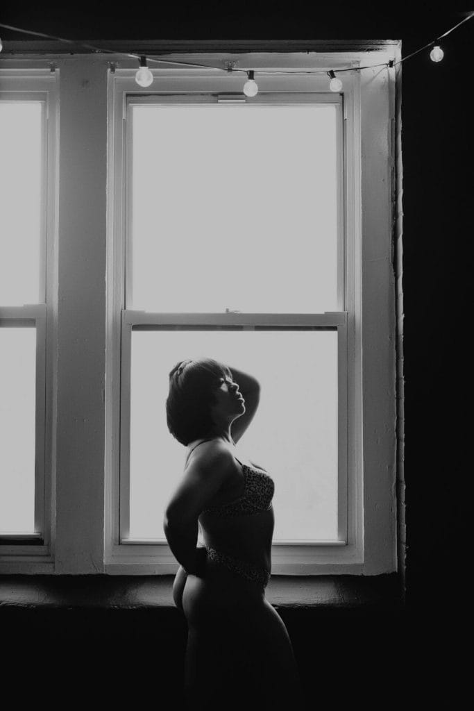 monochrome woman posing in front of window boudoir